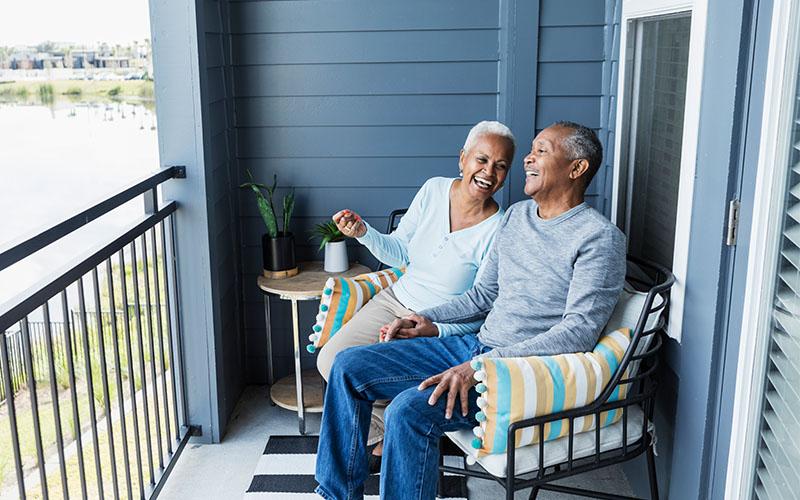 Two retirees sitting on their porch enjoying retirement