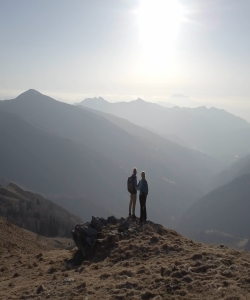Couple standing on top of a mountain looking at the view
